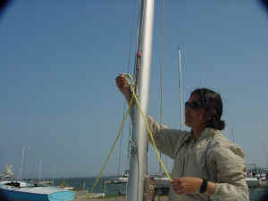 Passing the side-to-side bridle through the spinnaker ring and connecting it to to the main halyard. MasterHelper_2.jpg (202898 bytes)